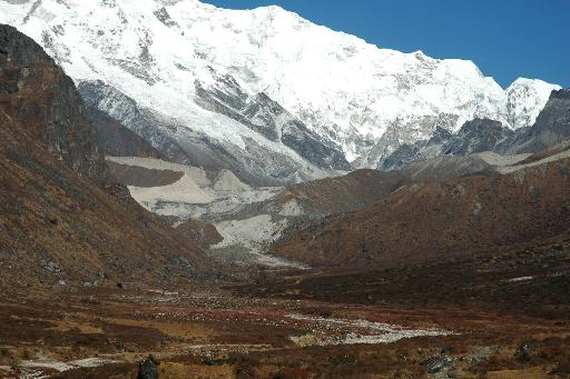 Lateral moraines in front of Kanchenjunga with a, now small, glacier, covered with rock debris and a river issuing from beneath it